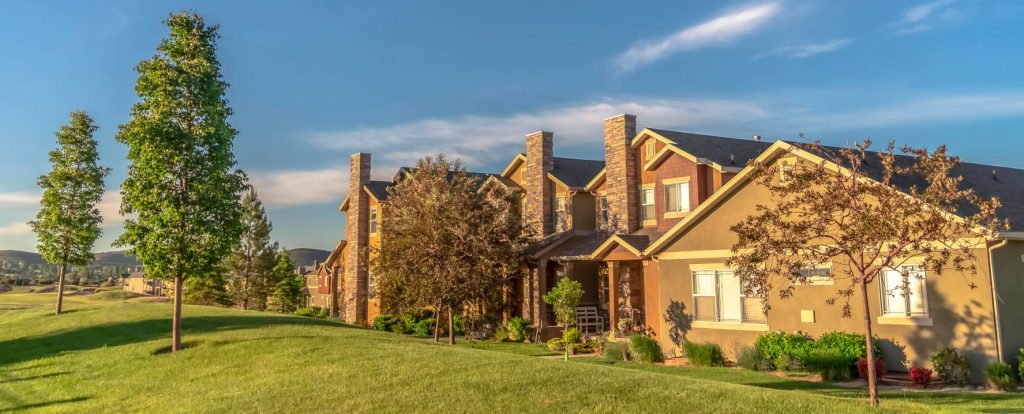 Spacious multi-story houses in a desirable neighborhood, surrounded by mature trees, well-maintained landscaping, and scenic mountain backdrops. Ideal for real estate buyers.