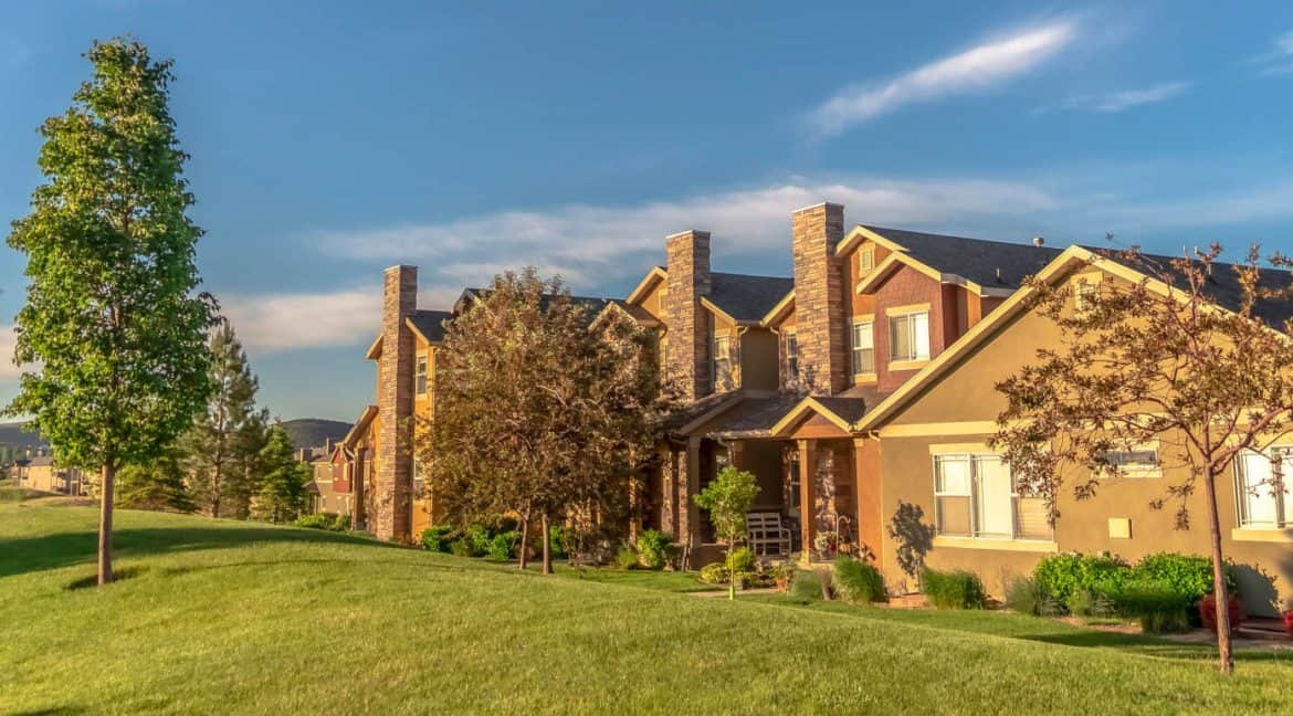 Beautiful Colorado residential homes surrounded by green lawns and trees, perfect for real estate listing, family living, and suburban comfort.